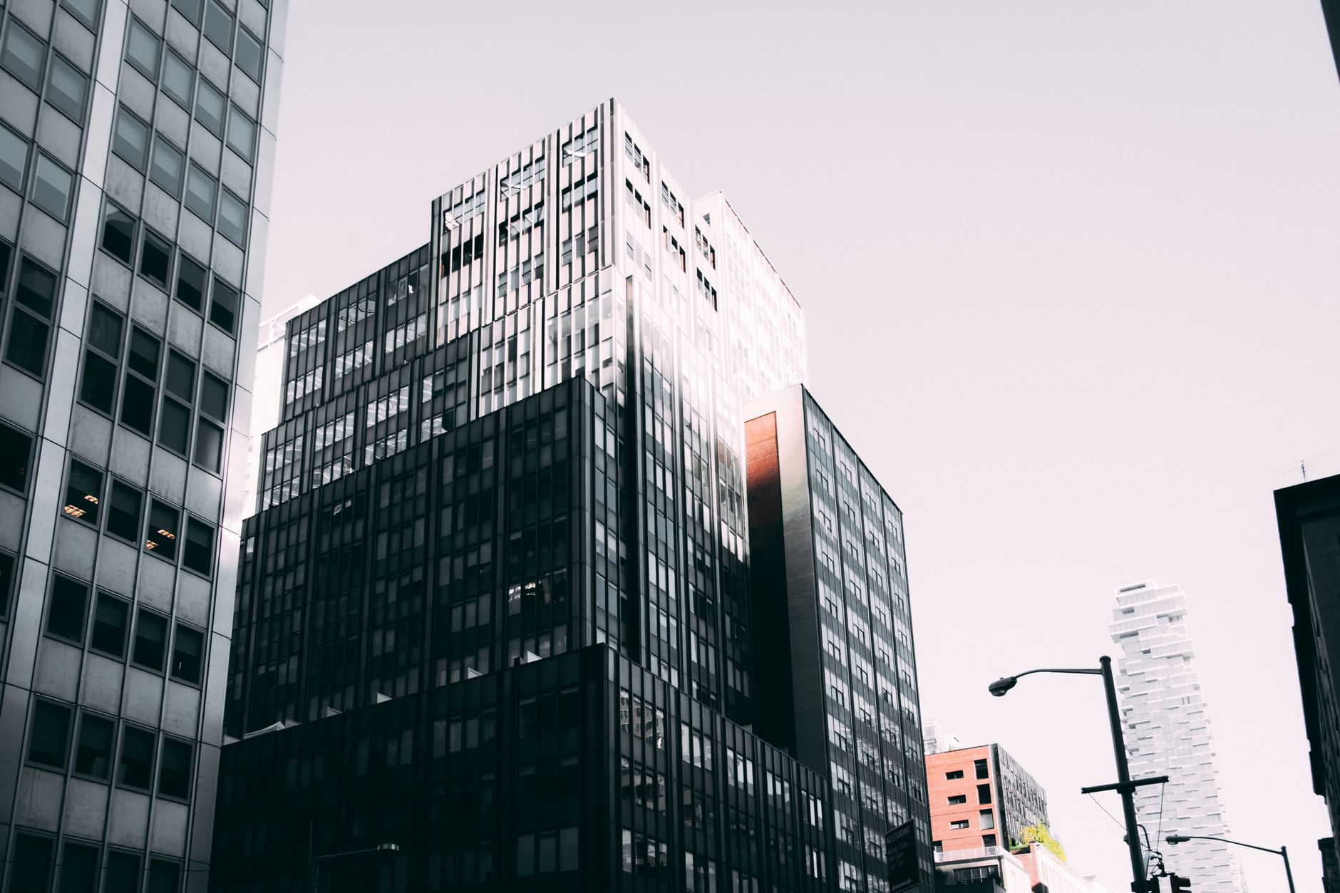 Modern office buildings with glass facades seen from a city street.