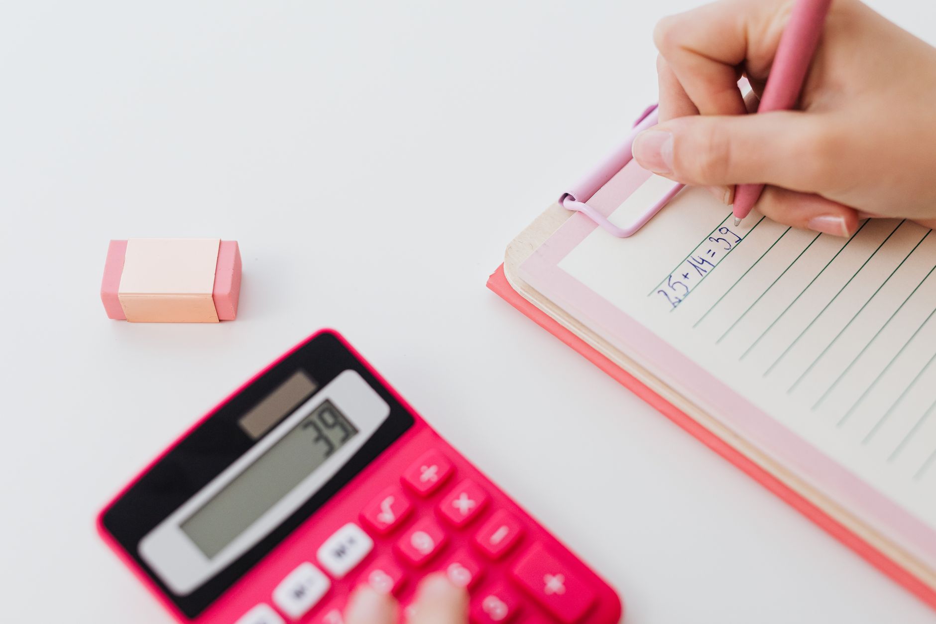 A notebook, a pen and a calculator on a desk.