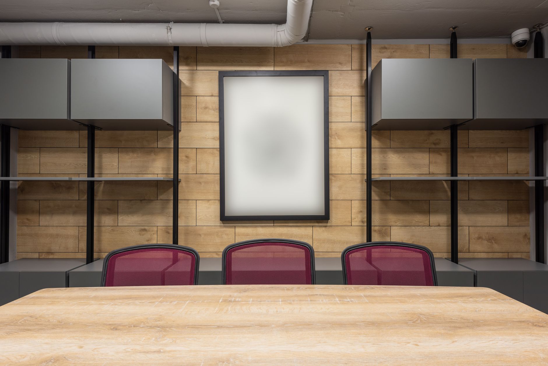 An empty office with a desk and chairs in daylight.