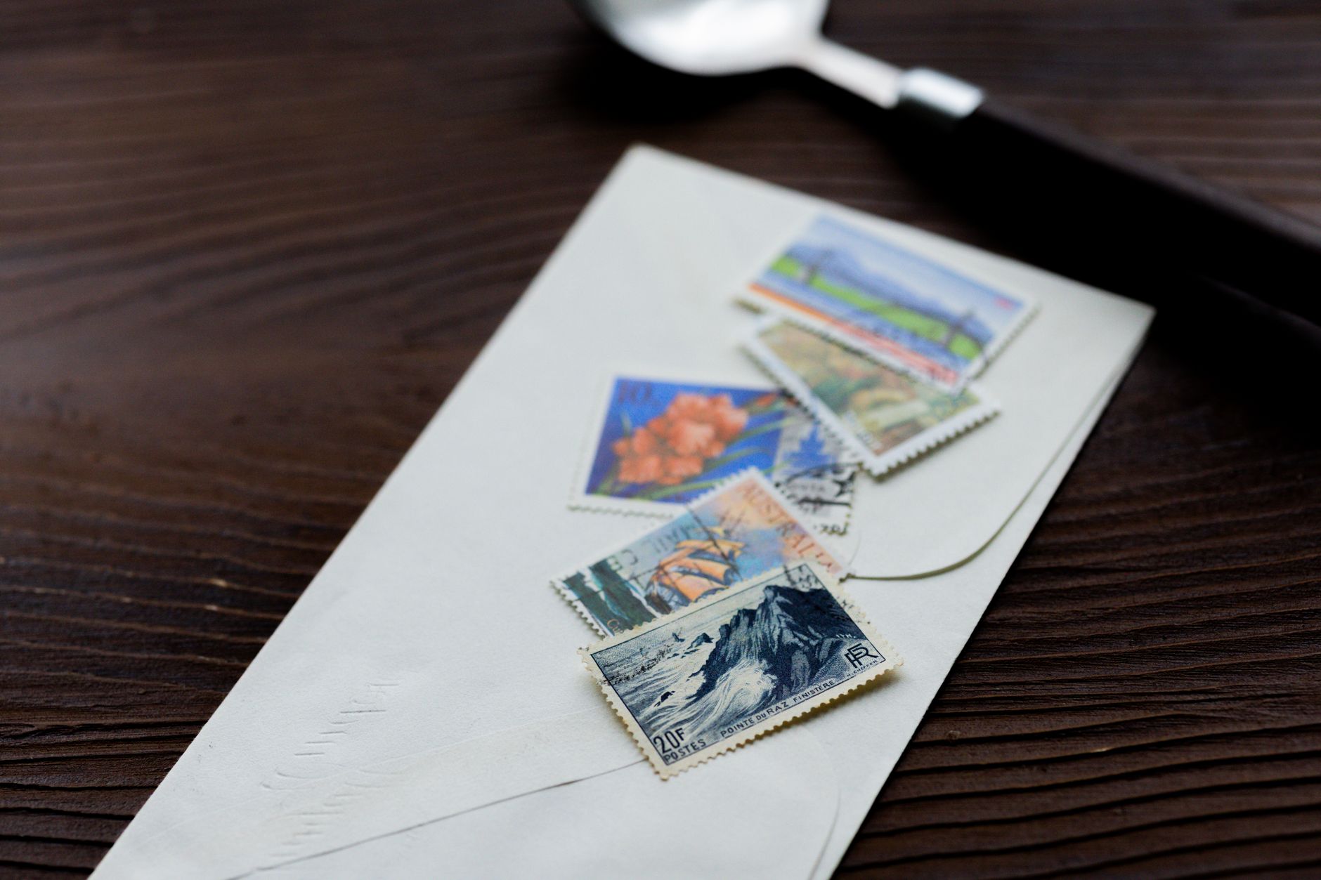 A stamped envelope lying on a wooden desk.