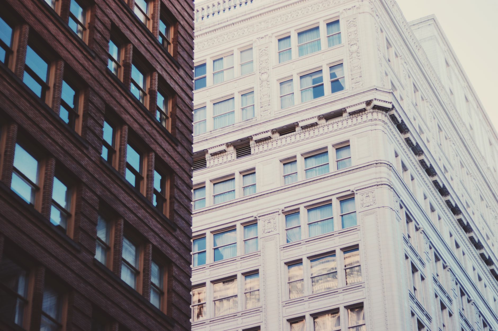 A row of office buildings along a city street in daylight.