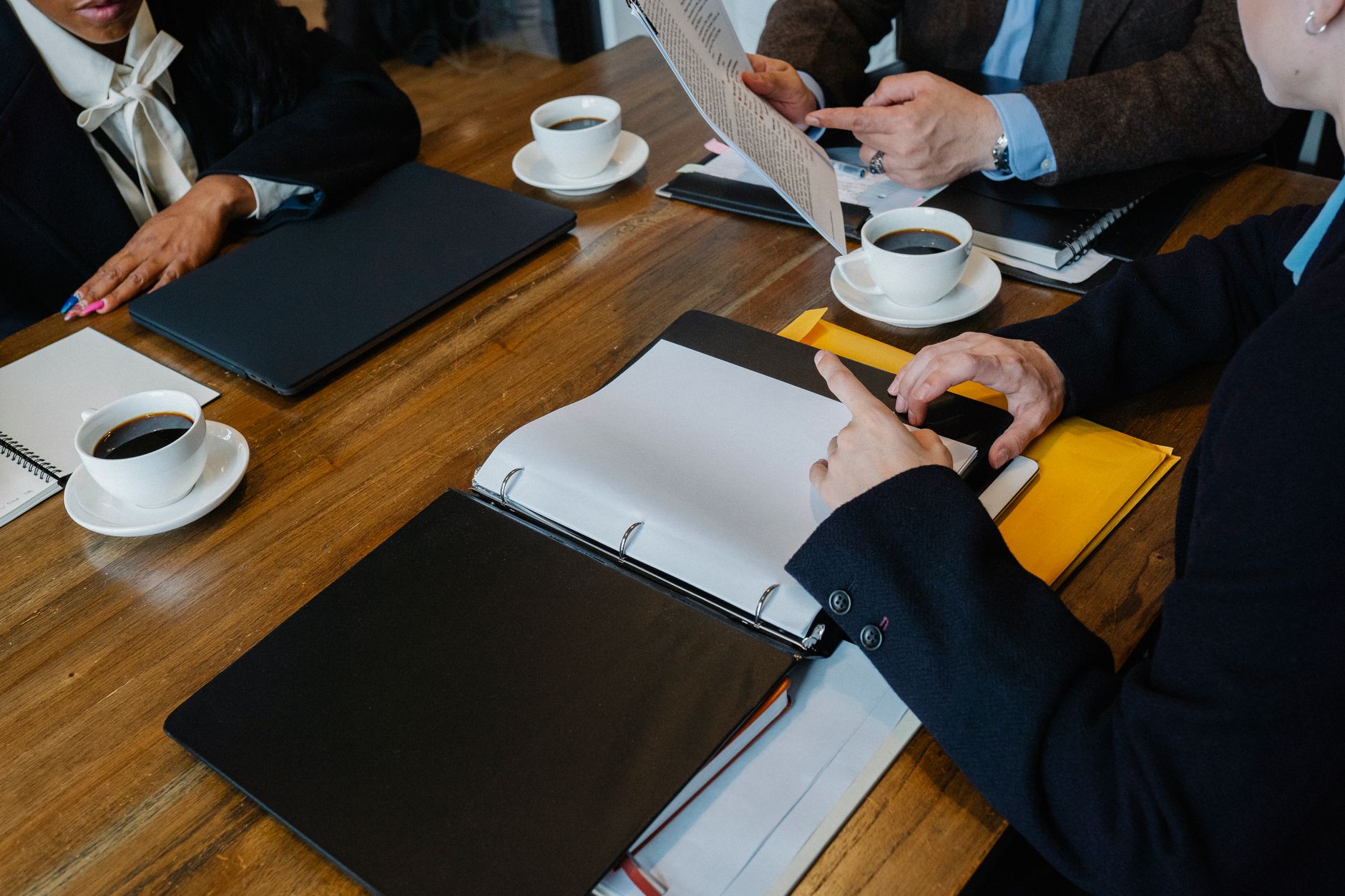 A meeting table with closed folders and blank notepads.