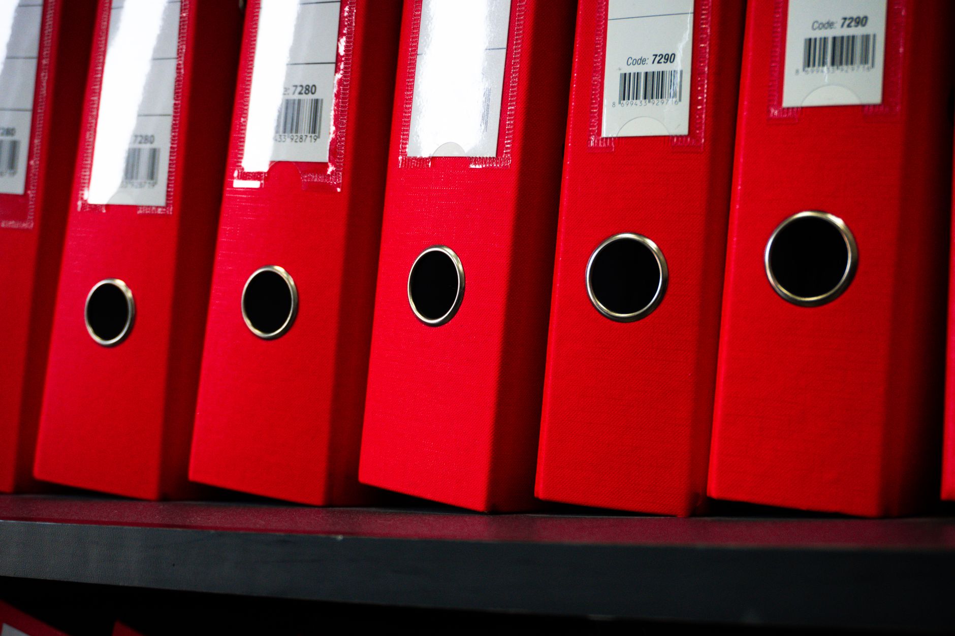 Rows of ring binders on an office shelf.