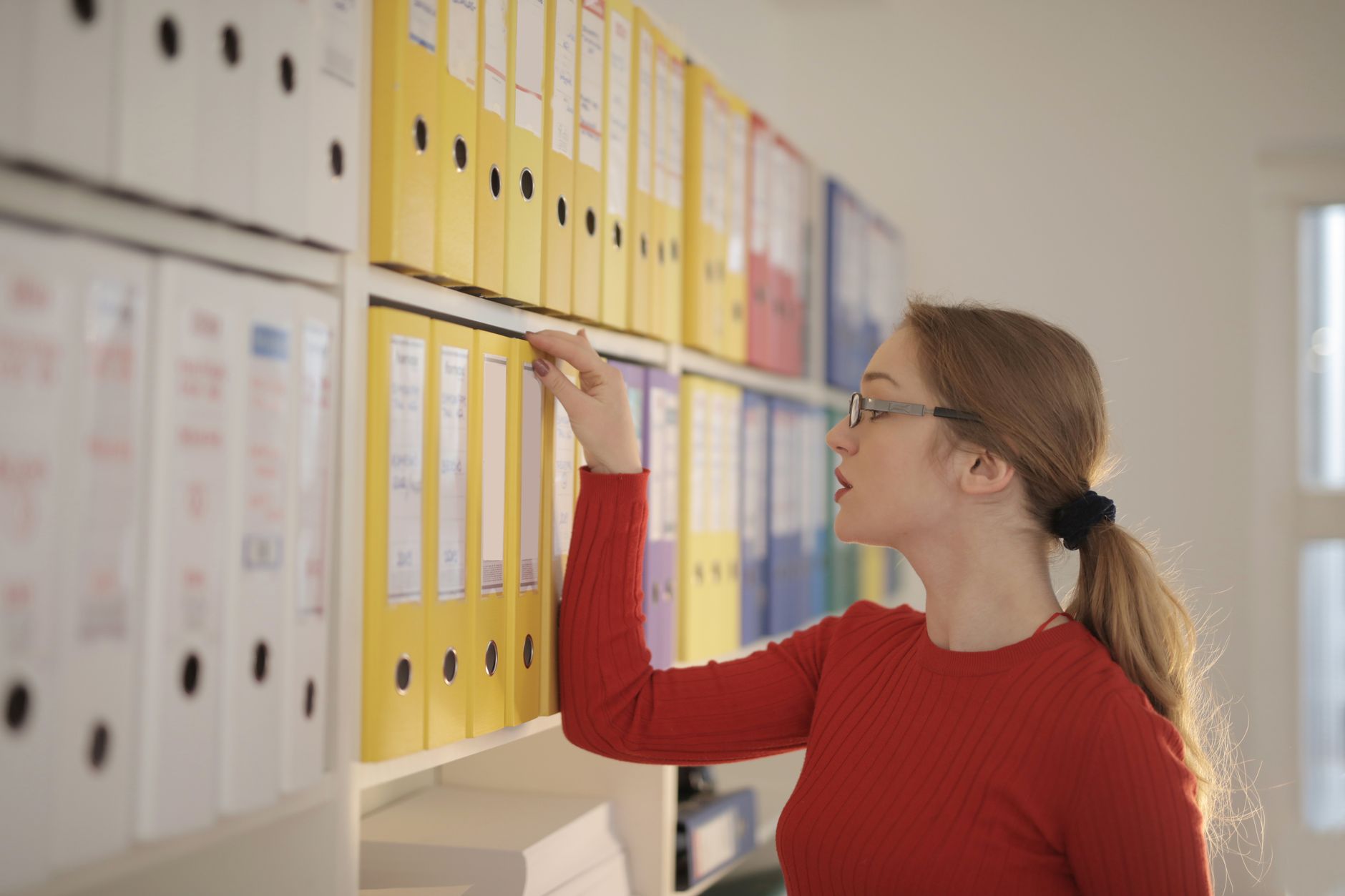 Shelves of closed binders and folders in an office.
