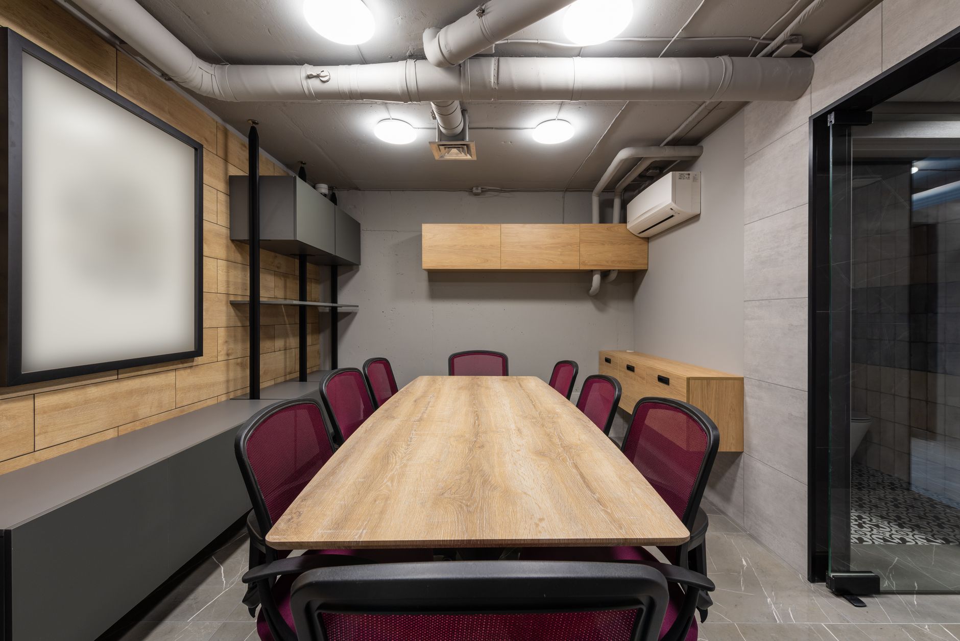 Two people sign papers at a meeting table in an office.