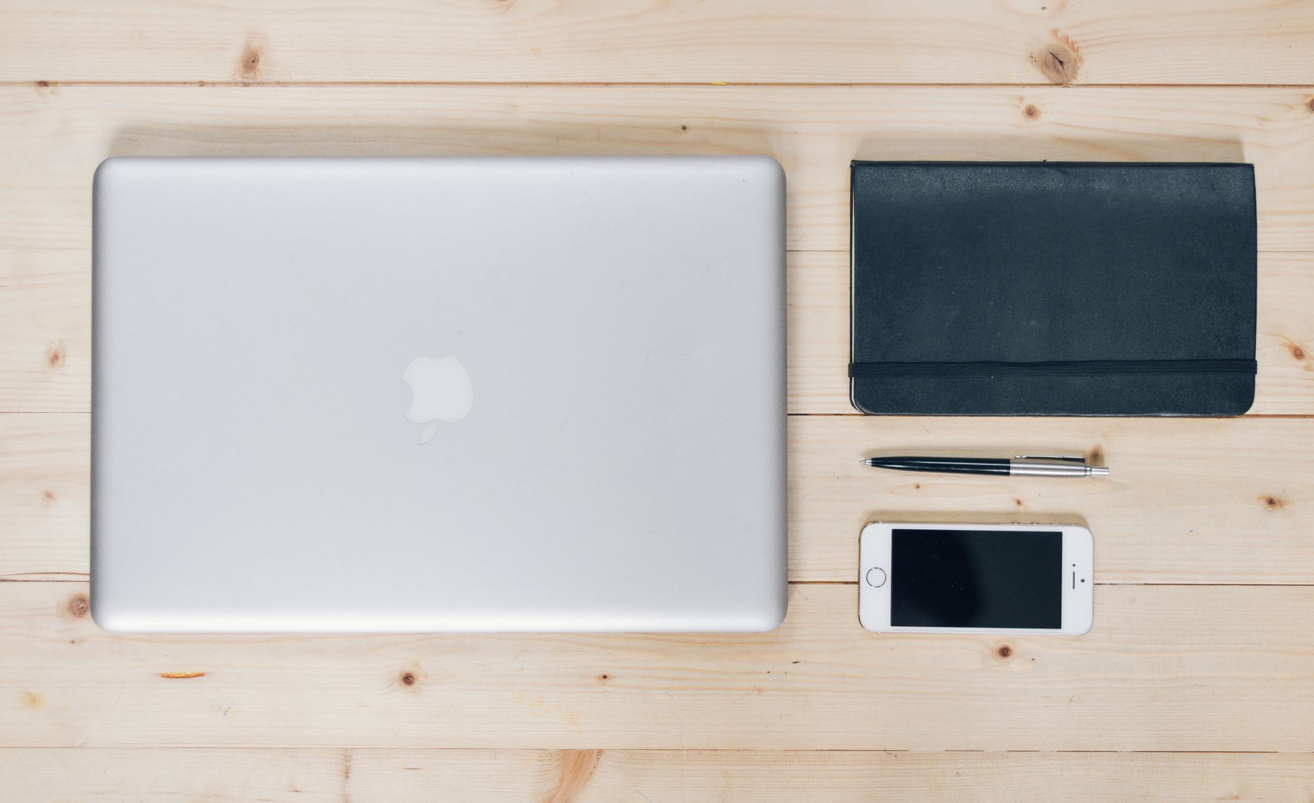 A neat stack of documents with a paper clip and a pen on a desk.