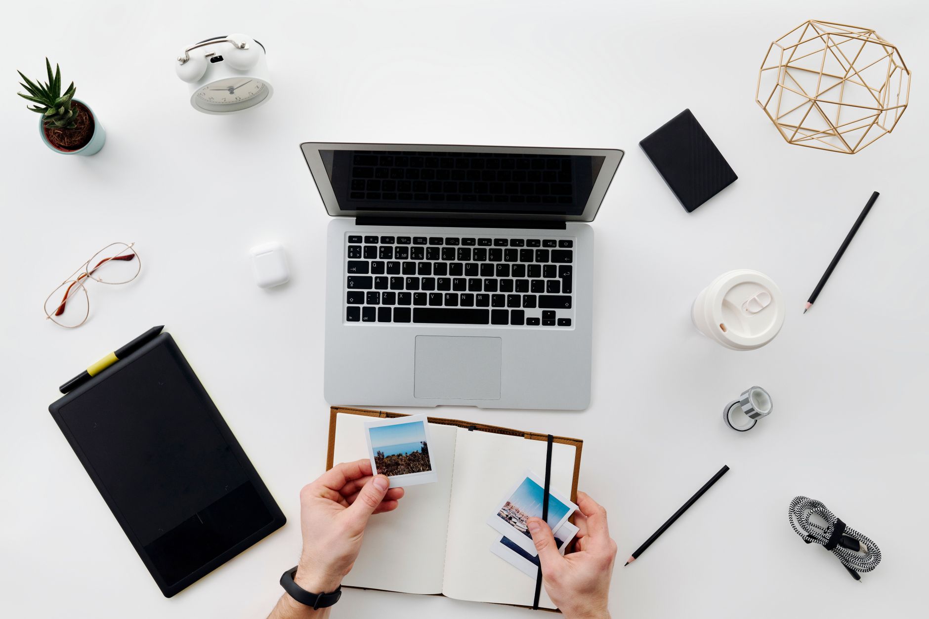 A top view of a home office desk with a laptop, a tablet and accessories.
