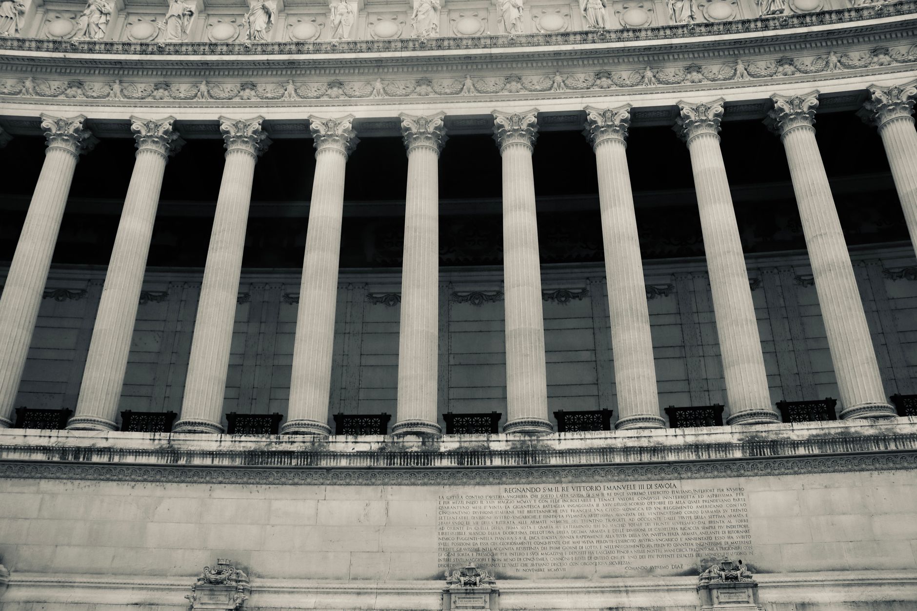 The stone facade of a public building with columns and tall windows.