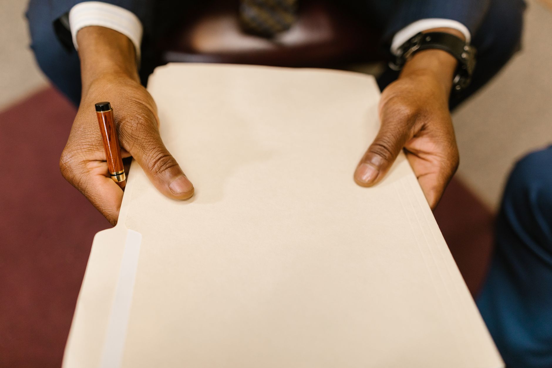 A folder of company documents and a pen on a desk.