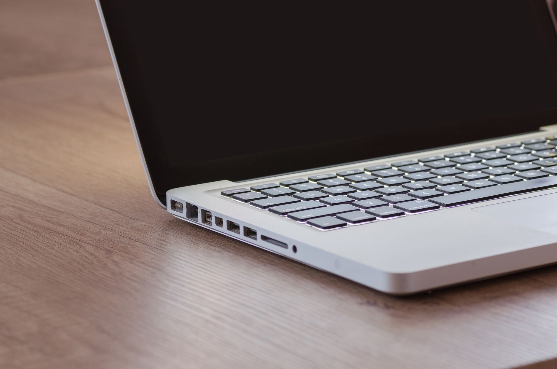 A rubber stamp and an ink pad on a wooden desk beside a closed folder.
