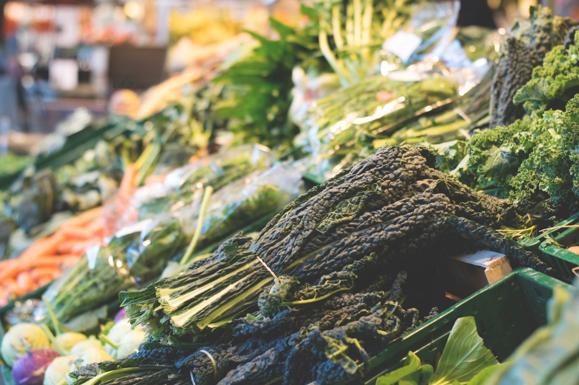 Fresh vegetables in crates at a market stall.