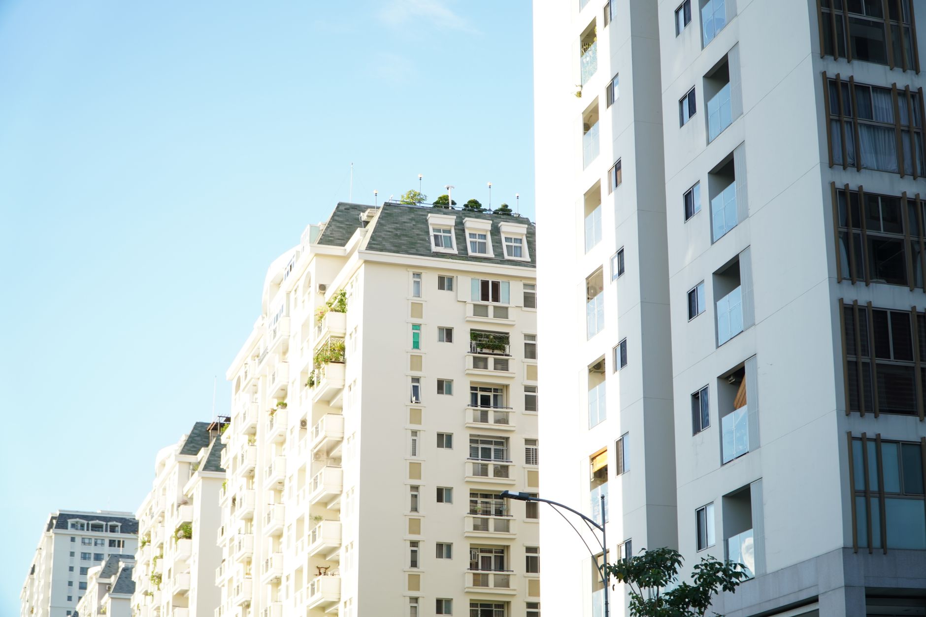 Apartment buildings with balconies seen from the street in daylight.